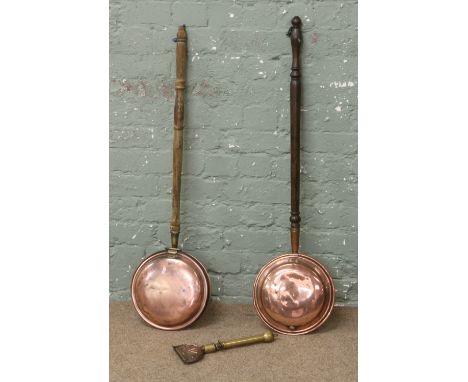 Two copper bed warming pans and an antique brass and copper horse singing tool.