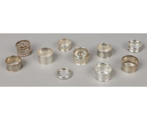 Ten assorted silver serviette rings including pierced and engine turned engraved examples, 135 grams.