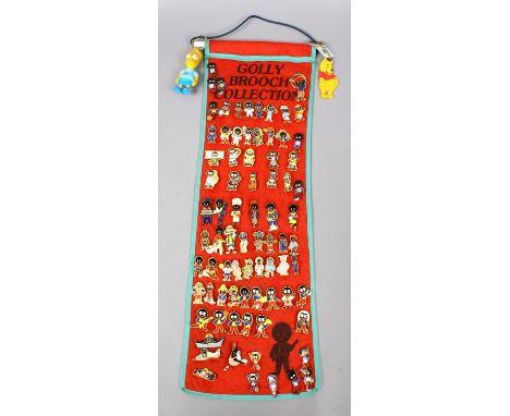 A large collection of Golly enamel brooches on hanging display including vintage examples.