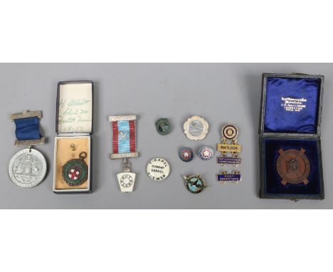 A group of late C19th/early C20th medals and bin badges including yellow metal and enamel examples.