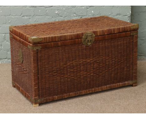 A wicker trunk with brass mounts.