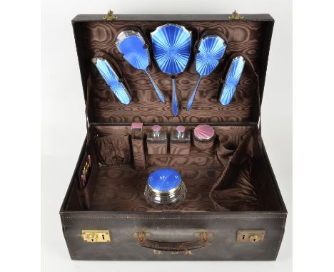 A 1940s ladies leather travelling vanity case containing silver mounted and guilloche enamel fittings, the brown leatherette 