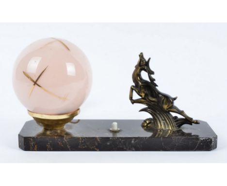 An Art Deco French onyx and gilt spelter table light, modelled as a leaping stag, next to a dusty pink and gilt spherical sha