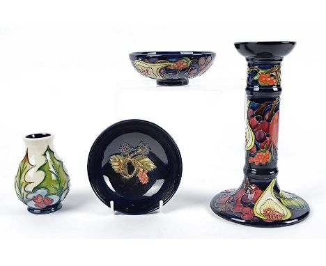 A contemporary Moorcroft Queens Choice pattern candlestick, 21cm high, two footed bowls in similar pattern, 12cm diameter and