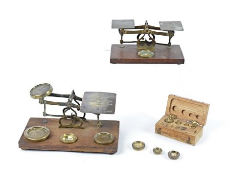 A set of Victorian brass postal scales and weights, together with another smaller pair and a cased set of brass weights, some