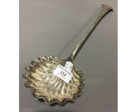 A large silver shell bowl ladle