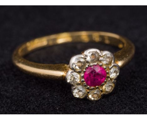 A gold, diamond and ruby set flowerhead ringSize K. Approximately 2 grammes all in.