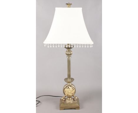 A tubular steel table lamp, with resin leaf central insert. Cream shade with beaded rim. Height: 78cm  