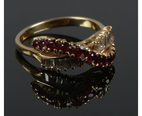 A vintage gold diamond and ruby crossover ring. Tests as 18ct. Size L. 4.02g.  