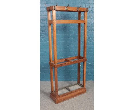 An oak coat and stick stand with two removable drip trays. Height 170cm, Width 69cm, Depth 23cm.  