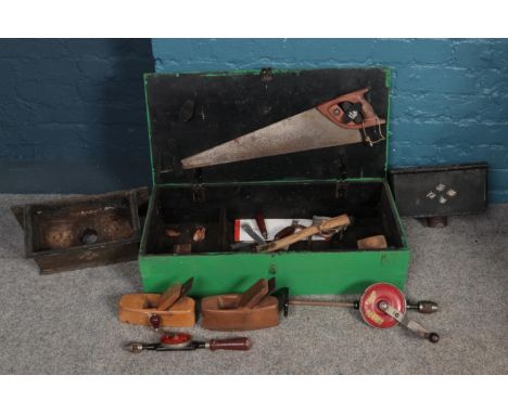 A large wooden tool box with an assortment of vintage tools, along with two cast iron Hopper heads. To include saw, hand dril