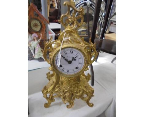 An ornate French mantel clock, a/f missing glass.