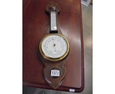 An oak barometer/thermometer.