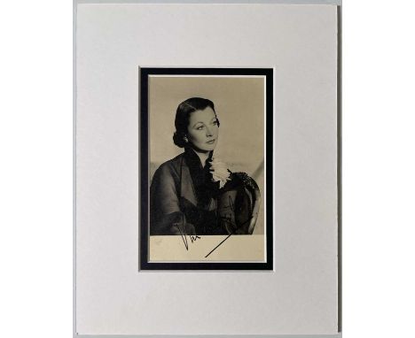 A vintage postcard sized image of Vivien Leigh, signed in black ink. Mounted to overall size 18.5 x 23cm.