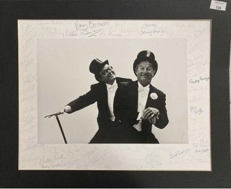 A large print of an image depicting Morecambe and Wise (49x38cm approx) with 50+ signatures from stars of stage and screen. T