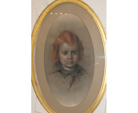 An early 20th century oval pastel portrait of a red haired boy, 55cm by 30cm