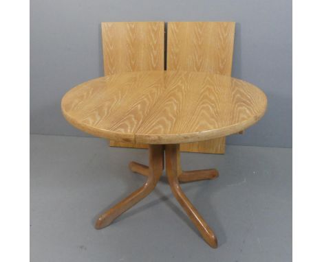 A mid century light oak circular drawer leaf dining-table with two spare leaves, believed to originally have been purchased f