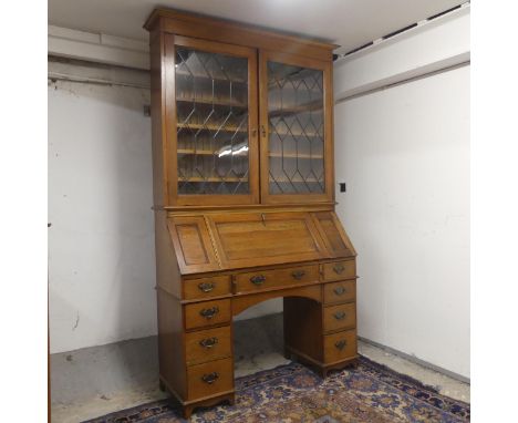 A early 20th Century oak two section bureau bookcase. Top section with two lead-light glazed doors. The lower with fall front