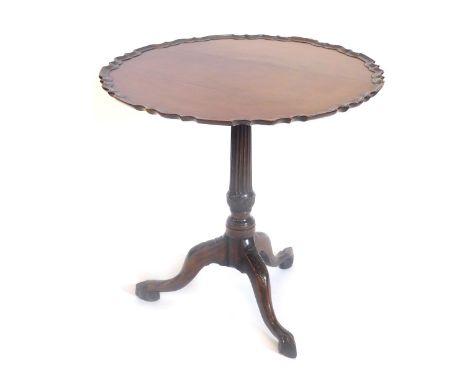 A mahogany occasional table, in George III style, the piecrust tilt top on a carved fluted turned column, on a leaf carved tr