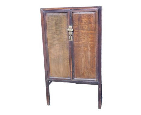 A Chinese hardwood cabinet, with two panelled doors, enclosing two drawers and a shelf, etc., 149cm high, 83cm wide.  Auction