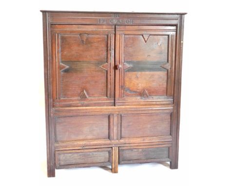 An oak cupboard, with carved frieze marked B over 17 GAO1, with two panel doors above four drawers terminating in stiles, 170