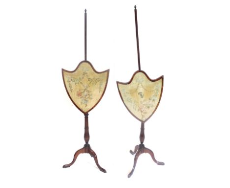 A pair of 19thC mahogany pole screens, each shield shaped banner inset with a floral silk panel embellished with an insect, e