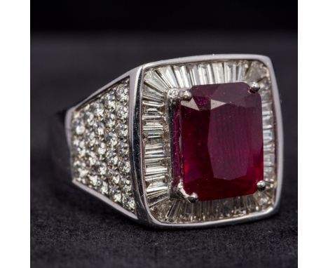 An 18 ct white gold, diamond and ruby set gentleman's ringThe facet cut claw set ruby flanked by a row of baguette cut diamon