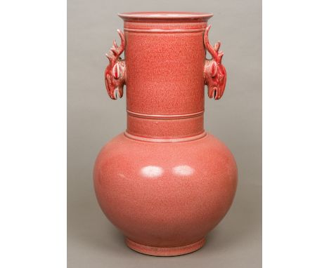 A large red ground Chinese pottery vaseThe elongated neck with twin deer mask handles, above the bulbous body.  52 cm high.  