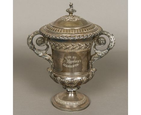 A George IV silver lidded twin handled trophy cup, hallmarked London 1824, maker's mark of JAThe scroll cast finial mounted r