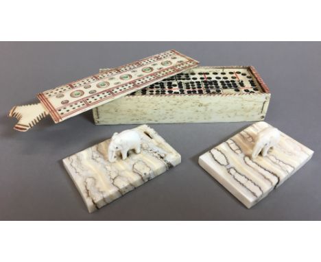 An early 19th century carved and polychrome decorated whale bone box enclosing dominoesThe sliding cover worked as a cribbage