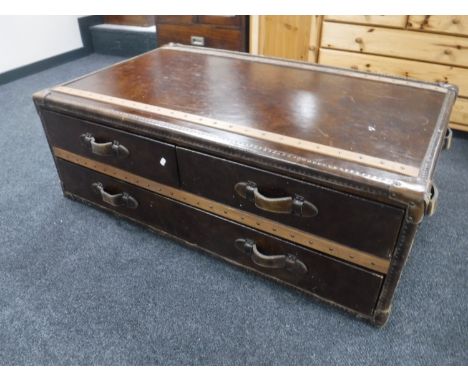A contemporary leather and canvas coffee table in the form of a shipping trunk 
