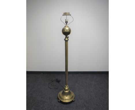 An antique brass Corinthian column standard lamp on ball feet   