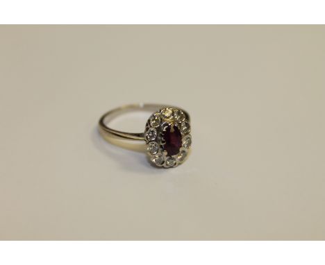 A 14ct white gold ruby and diamond cluster ring, size M