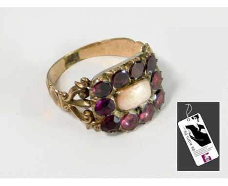 19th CENTURY RING. A 19th century pink enamel & faceted garnet ring. The closed back setting with repairs. Size N/O. Original