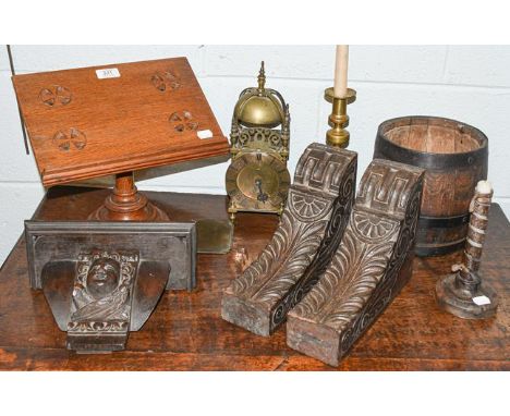 A 18th century carved oak wall bracket decorated with a putto mask, two carved oak corner brackets, a 17th century candle sti