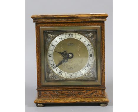 A carved oak cased Elliott mantel clock.