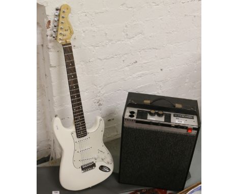 An electric guitar after fender Stratocaster with carry case along with a Pianomate amplifier.