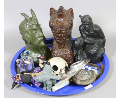 A tray of collectables including devil ornaments, magnifying glass, compass and a fossil.