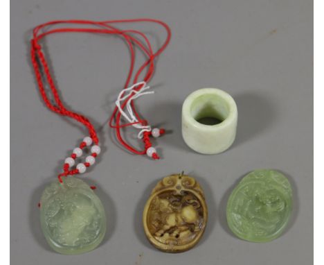 Three pieces of oriental carved jade pendants along with a jade archers ring.