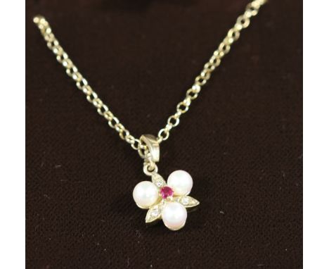 A ladies 9 carat gold pendant set with diamonds, ruby and pearls on a 9 carat gold necklace, 3.65 grams.