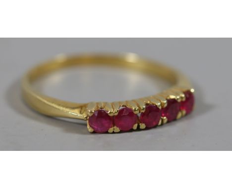 A continental high carat gold five stone ruby ring. Hallmarks to the outside of the shank, size R.