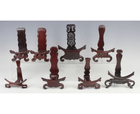 A pair of Chinese hardwood dish stands, early 20th century, each carved with a bat and scroll front panel, height 17.8cm, tog
