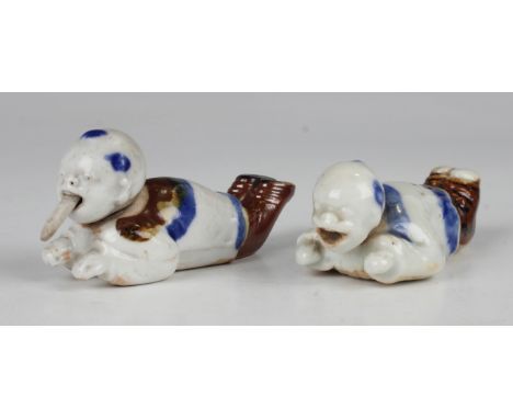 Two rare Japanese Hirado porcelain netsuke figures, Edo period, each modelled as a recumbent Chinese boy with nodding head an