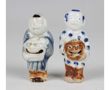 Two rare Japanese Hirado porcelain netsuke rattles, Edo period, each modelled as a Chinese boy holding a lion mask, wearing a