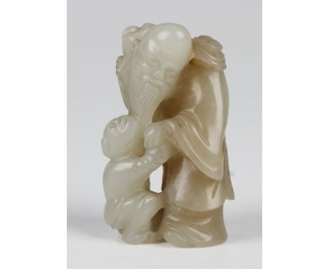 A Chinese pale celadon jade carving, probably late Qing dynasty, carved and pierced in the form of Shoulao and attendant chil