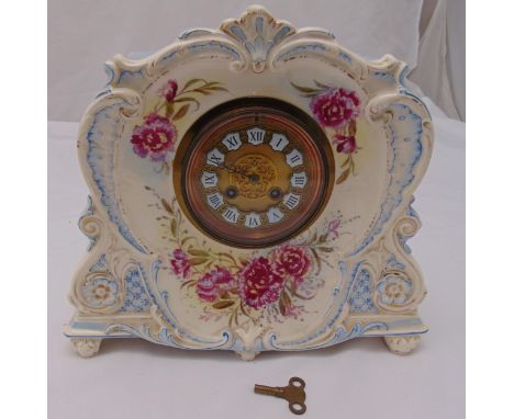 A continental porcelain mantle clock with circular dial and Roman numerals the case decorated with floral sprays, 31 x 34.5x 
