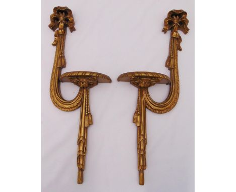 A pair of gilded wooden wall mounted shelves in the form of a sash with ribbon finials, 58 x 21 x 9cm