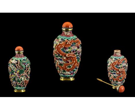 A Qianlong period Snuff Bottle. A Qianlong period moulded and carved snuff bottle with a Dragon and Phoenix chasing the flami
