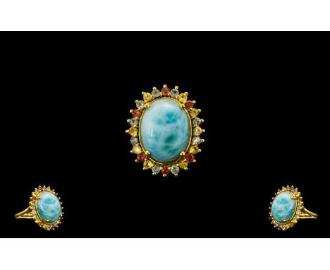 Green, Yellow and Sunset Sapphire Haloed Larimar Ring, a 10ct cabochon of the natural, opaque, beautifully mottled sky blue l