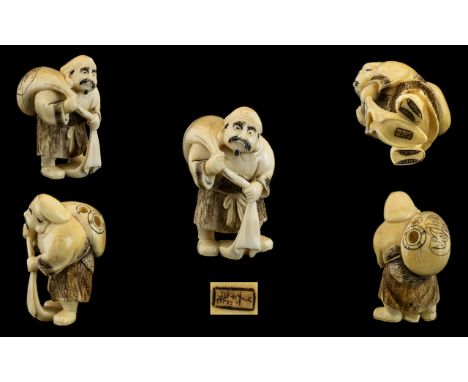 Japanese - Mid 19th Century Signed Well Carved Ivory Netsuke Depicts a Male Figure Carrying a Large Sack Over His Shoulders. 